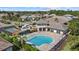 Aerial view of a community pool, tennis courts and clubhouse surrounded by manicured landscaping at 19800 Montenero Way, Venice, FL 34293