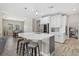 Open kitchen with white cabinetry, island seating, pendant lights, and stainless steel appliances at 19800 Montenero Way, Venice, FL 34293