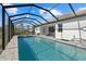 Screened-in pool and hot tub with outdoor kitchen and dining area, offering resort-style living at 19800 Montenero Way, Venice, FL 34293