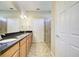 Bathroom boasts double sinks with granite countertops, a framed shower, and two doors at 19911 Quisto St, Venice, FL 34293