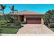 Beautiful single-story home featuring a clay tile roof, brick driveway, and manicured landscaping with palm trees at 19911 Quisto St, Venice, FL 34293