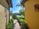 Charming walkway with lush landscaping leading to a lovely home with vibrant curb appeal at 19911 Quisto St, Venice, FL 34293