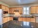 Gourmet kitchen with granite countertops and stainless steel appliances and wood cabinets at 19911 Quisto St, Venice, FL 34293