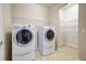 Laundry room with washer, dryer, storage, and tile floors at 19911 Quisto St, Venice, FL 34293
