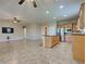 Open-concept living room with tile floors, ceiling fan, and a view of the kitchen at 19911 Quisto St, Venice, FL 34293