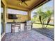 Outdoor kitchen with bar, sink, refrigerator, and stainless steel grill at 19911 Quisto St, Venice, FL 34293