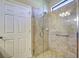 Tiled shower with glass enclosure, grab bar, and a handheld shower head at 19911 Quisto St, Venice, FL 34293