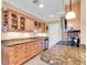 Well-lit kitchen features granite countertops, modern appliances, and stylish wood cabinetry at 200 The Esplanade N # B3, Venice, FL 34285