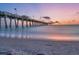 Long pier extending into the tranquil ocean at sunset, with a sandy beach foreground at 200 The Esplanade N # B3, Venice, FL 34285