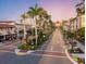 Picturesque street lined with palm trees, quaint shops and buildings, and colorful landscaping at 200 The Esplanade N # B3, Venice, FL 34285