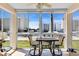 A sunroom with a table and chairs provides a relaxing space with a view of the building at 200 The Esplanade N # B3, Venice, FL 34285