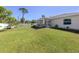 Spacious backyard with lush green lawn, white fence, and view of the screened patio at 2098 Zellwood Ter, North Port, FL 34286