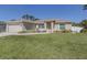 Charming single-story home with a well-manicured lawn and beige stucco exterior with attached garage at 2098 Zellwood Ter, North Port, FL 34286