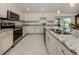 Modern kitchen features white cabinets, stainless steel appliances, and granite countertops at 2098 Zellwood Ter, North Port, FL 34286
