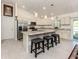 Bright kitchen with stainless steel appliances, large island with seating and pendant lighting at 2098 Zellwood Ter, North Port, FL 34286