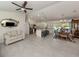 Spacious living area featuring tile flooring, a ceiling fan, and a clear view into the kitchen and dining room at 2098 Zellwood Ter, North Port, FL 34286