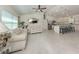 Open concept living room with tile floors, white couches, and kitchen view at 2098 Zellwood Ter, North Port, FL 34286