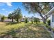 A lush backyard view featuring mature trees and landscaping, with storage shed at 2102 Alaric St, Port Charlotte, FL 33952