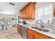 Bright kitchen featuring granite countertops, wood cabinetry, stainless steel appliances, and tile flooring at 2102 Alaric St, Port Charlotte, FL 33952