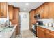 Well-lit kitchen featuring warm wood cabinetry, granite countertops, and stainless-steel appliances at 2102 Alaric St, Port Charlotte, FL 33952