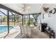 Screened patio dining area with ceiling fan overlooking pool and backyard at 2102 Alaric St, Port Charlotte, FL 33952