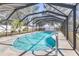 Sparkling pool in screened enclosure with stainless steel handrail at 2102 Alaric St, Port Charlotte, FL 33952