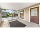 The screened lanai features neutral tones, a sleek black rug, a large window and an entry door at 2209 Woodmere Rd, Venice, FL 34293