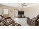 Bright living room with white tile flooring, a ceiling fan and plush, leather reclining furniture at 2209 Woodmere Rd, Venice, FL 34293