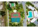 Aerial view featuring tennis courts, shuffleboard, and community pool surrounded by trees at 223 Lancer Dr, Nokomis, FL 34275