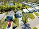 An aerial view shows well-maintained homes with a red car and a golf cart parked outside at 223 Lancer Dr, Nokomis, FL 34275