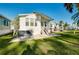 Backyard view of home featuring well-maintained lawn and a small deck at 223 Lancer Dr, Nokomis, FL 34275