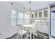 Bright dining area with white table set, chandelier, and natural light from bay windows at 223 Lancer Dr, Nokomis, FL 34275