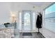 Bright entryway with white framed front door, coat rack, and gray wood laminate flooring at 223 Lancer Dr, Nokomis, FL 34275