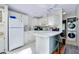 Bright kitchen featuring white appliances, countertops, and cabinets, connected to laundry area at 223 Lancer Dr, Nokomis, FL 34275