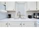 Clean kitchen sink with ample countertop space, stainless steel faucet, and white cabinets at 223 Lancer Dr, Nokomis, FL 34275