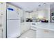 Clean kitchen with white appliances, countertops, and tile backsplash and flooring at 223 Lancer Dr, Nokomis, FL 34275