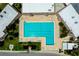 Aerial view of a community pool surrounded by lounge chairs and palm trees at 223 Lancer Dr, Nokomis, FL 34275