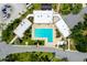 Aerial view of a community pool with lounge chairs surrounded by palm trees and buildings at 223 Lancer Dr, Nokomis, FL 34275