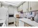 Bright kitchen with white cabinets, appliances, and a view into the living room at 238 Tampa W Ave # 217, Venice, FL 34285