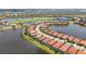 Aerial view of a community with lake views, red tile roofs, and lush greenery at 23823 Waverly Cir, Venice, FL 34293
