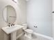 Bathroom with pedestal sink, oval mirror, and tile floors at 23823 Waverly Cir, Venice, FL 34293