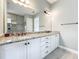 Bathroom featuring double sinks with granite counters and white cabinetry at 23823 Waverly Cir, Venice, FL 34293