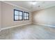 Bedroom with a view, featuring tile flooring, black window frames, and a ceiling fan at 23823 Waverly Cir, Venice, FL 34293