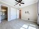Bright bedroom featuring a ceiling fan, tile floors, closet, and a view to the bathroom at 23823 Waverly Cir, Venice, FL 34293