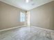 Empty bedroom featuring tile floors, base trim, and a window at 23823 Waverly Cir, Venice, FL 34293
