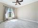 Bright bedroom with tile floors, ceiling fan, neutral walls, and a window with views of the outdoors at 23823 Waverly Cir, Venice, FL 34293