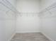 Spacious walk-in closet features wire shelving and neutral tile flooring at 23823 Waverly Cir, Venice, FL 34293
