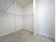 Walk-in closet features wire shelving and neutral tile flooring at 23823 Waverly Cir, Venice, FL 34293