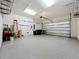 Spacious garage with epoxy flooring, shelving units, and an insulated garage door at 23823 Waverly Cir, Venice, FL 34293