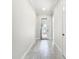 Bright hallway with gray tile floors, white trim, and a glass door leading to the outside at 23823 Waverly Cir, Venice, FL 34293